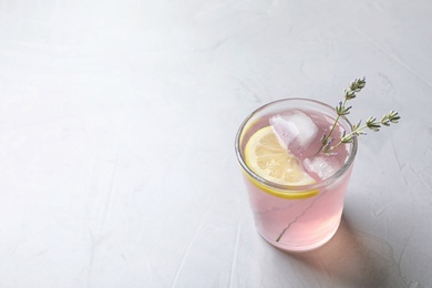 Photo of Natural lemonade with lavender in glass on light background