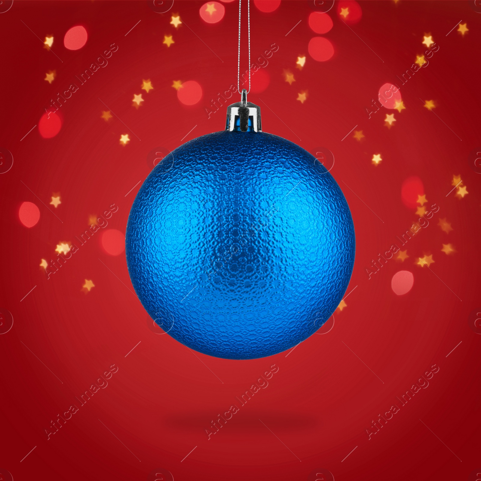 Image of Beautiful blue Christmas ball hanging on red background