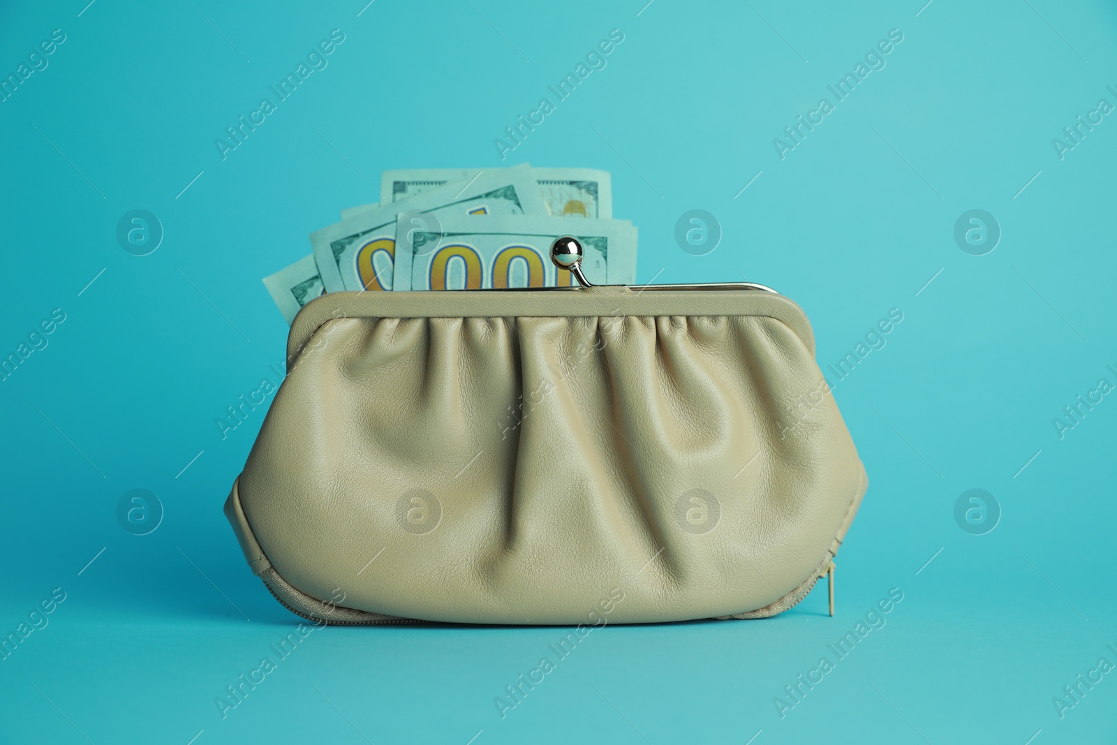 Photo of One stylish leather purse with money on light blue background