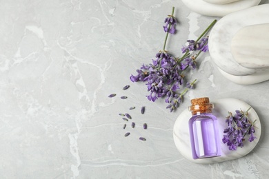 Photo of Stones, bottle of essential oil and lavender flowers on marble table, flat lay. Space for text