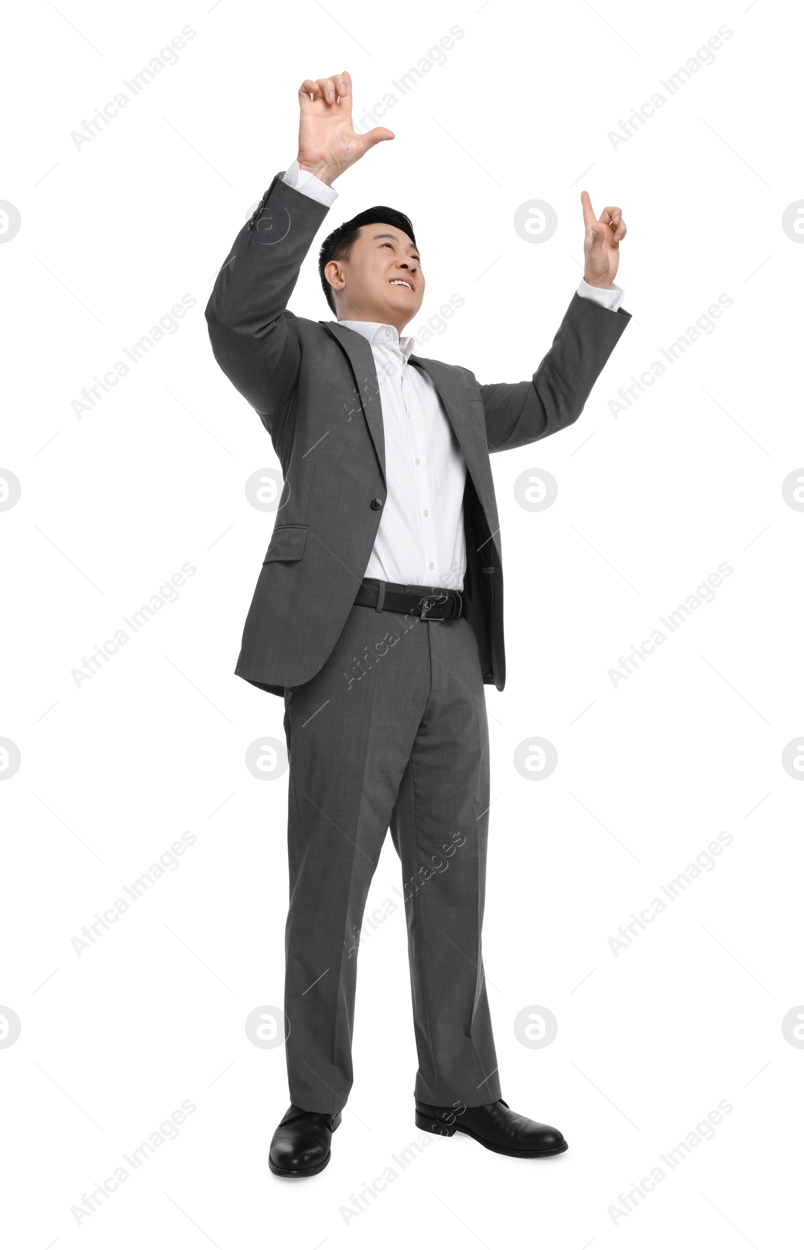 Photo of Businessman in suit posing on white background, low angle view