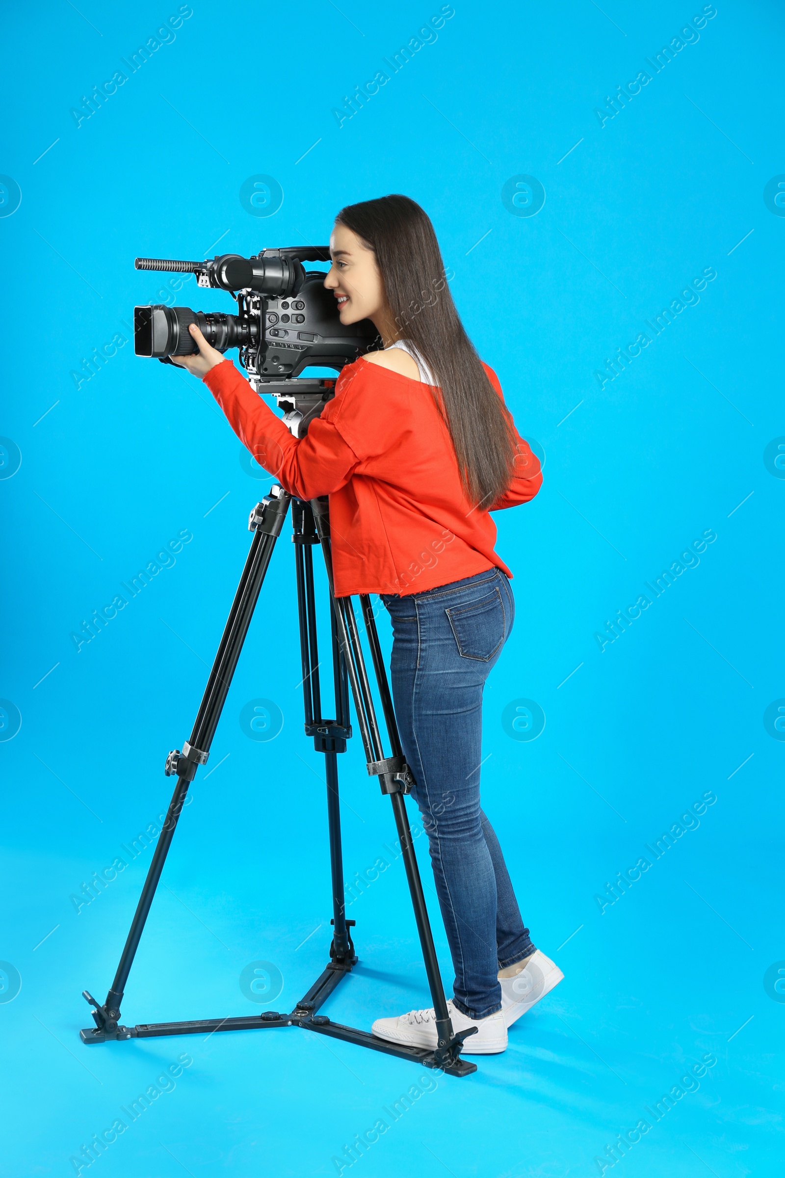 Photo of Operator with professional video camera on blue background