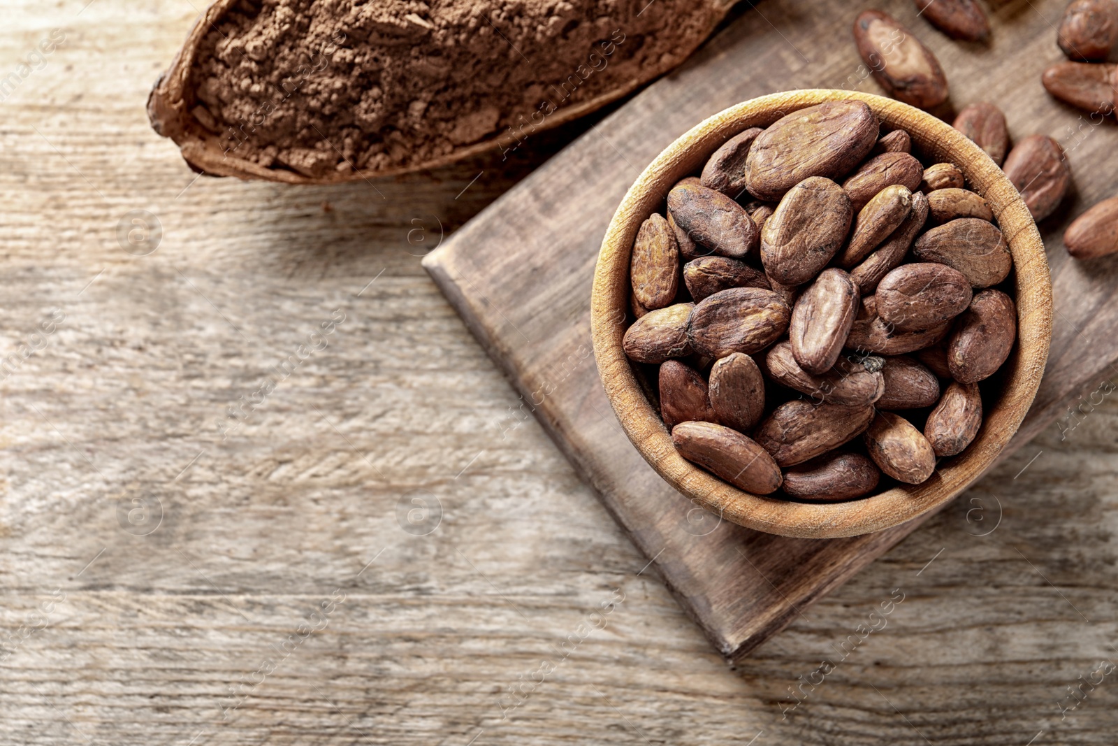 Photo of Flat lay composition with cocoa beans and powder on wooden table, space for text