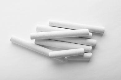 Photo of Pieces of chalk on white background, top view