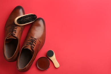 Flat lay composition with shoe care accessories and footwear on red background. Space for text