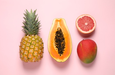 Fresh ripe papaya and other fruits on pink background, flat lay