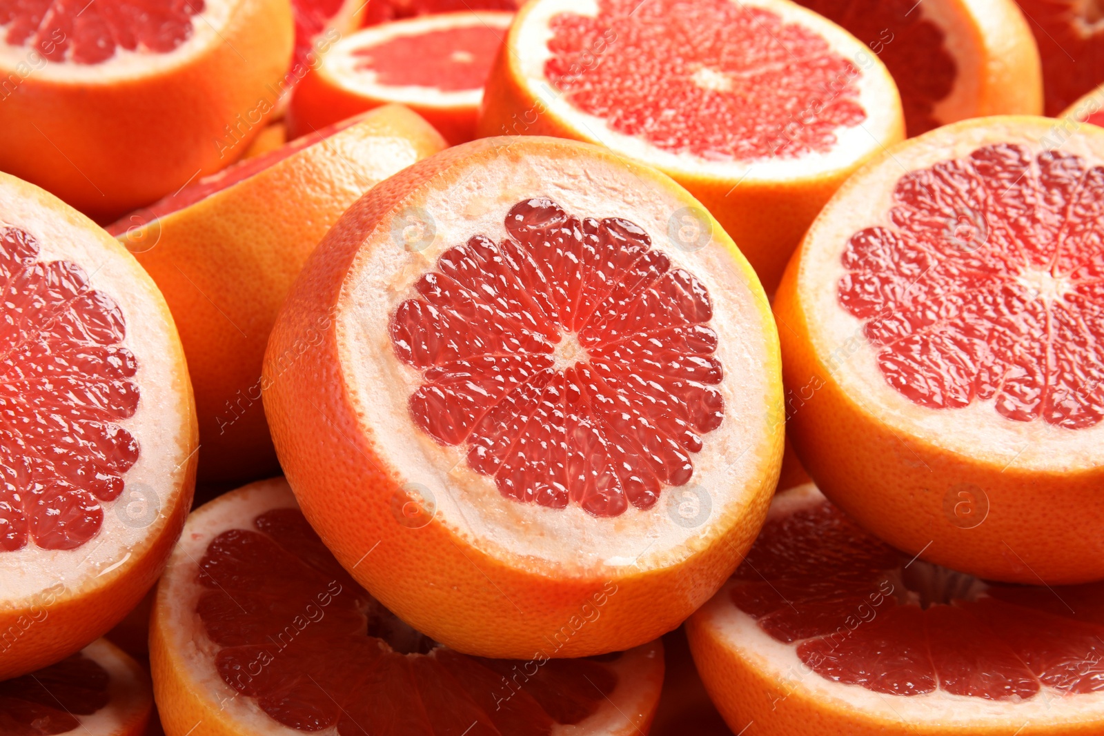 Photo of Many sliced fresh ripe grapefruits as background, closeup