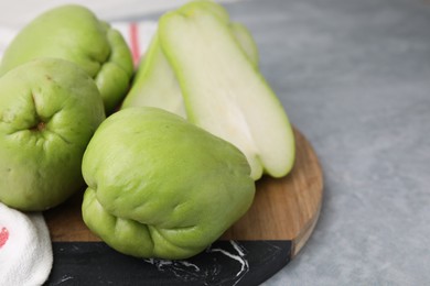 Cut and whole chayote on gray table, closeup