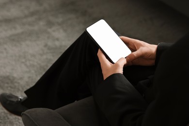 Photo of Man using smartphone with blank screen indoors, closeup. Mockup for design