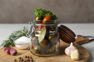 Photo of Pickling jar with fresh ripe tomatoes on white table