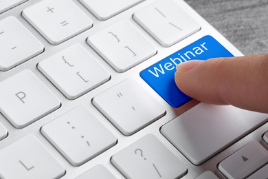 Image of Online learning. Woman pressing button on computer keyboard with word Webinar, closeup