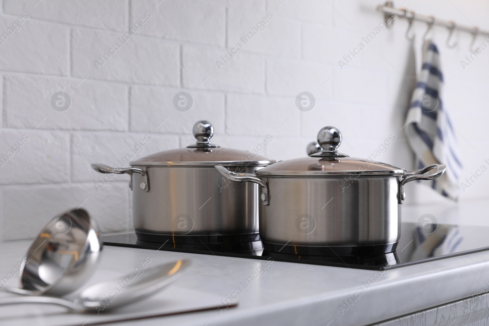 Photo of New clean pots on cooktop in kitchen