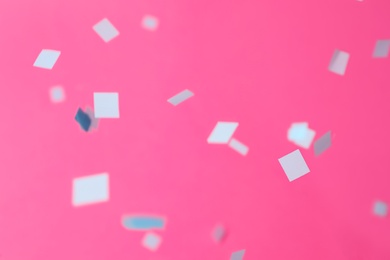 Photo of Grey confetti falling down on pink background