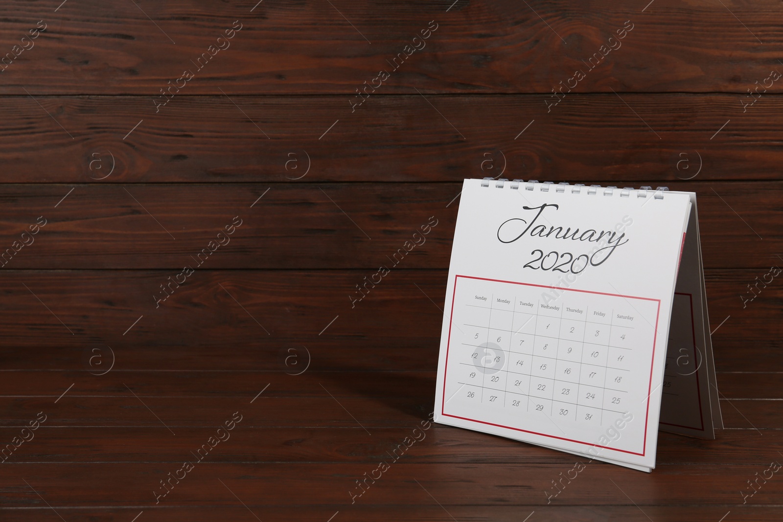 Photo of Paper calendar on wooden table, space for text