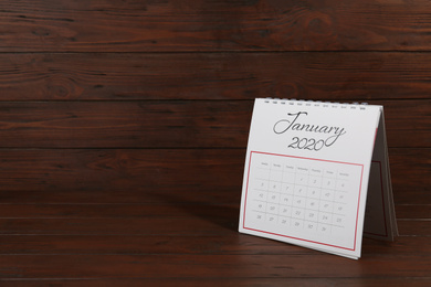 Photo of Paper calendar on wooden table, space for text