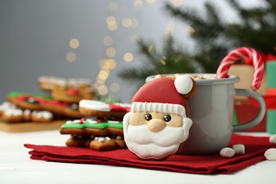 Tasty homemade Christmas cookie and hot drink with marshmallows on white table