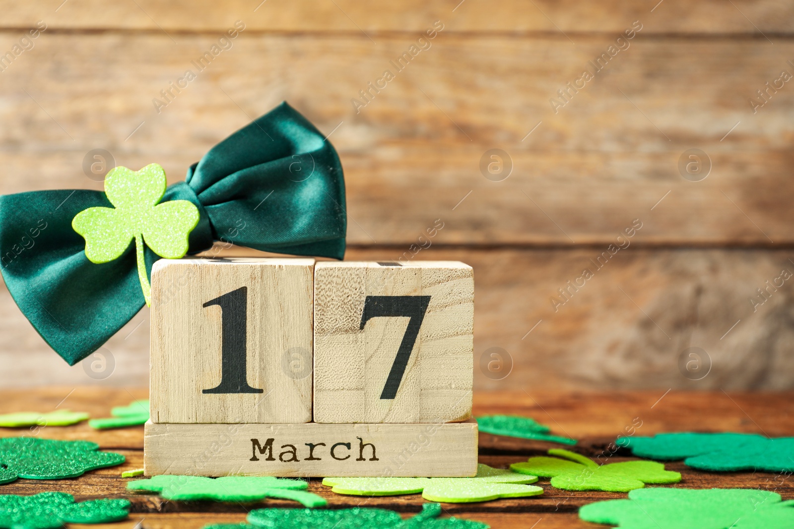 Photo of Composition with block calendar on wooden table, space for text. St. Patrick's Day celebration