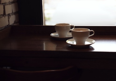 Cups of fresh aromatic coffee on table