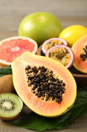Photo of Fresh ripe papaya and other fruits on wooden table, closeup