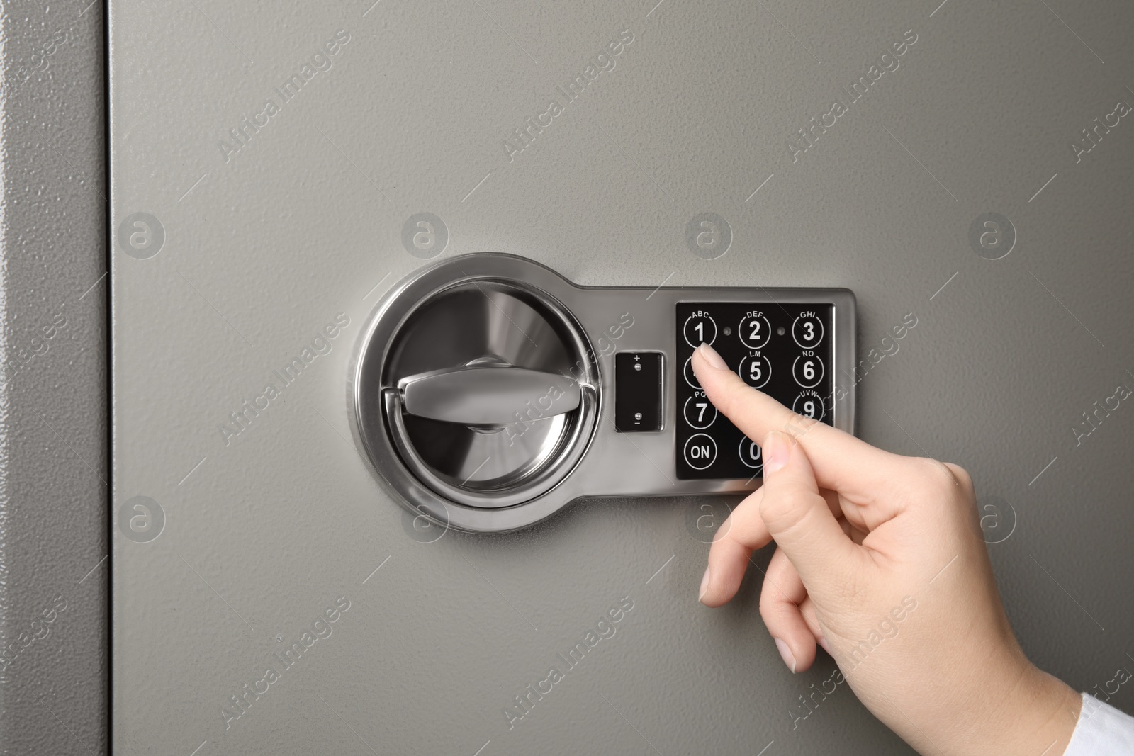 Photo of Woman opening steel safe with electronic lock, closeup