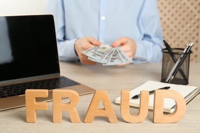 Photo of Word Fraud and blurred view of woman with money on background. Space for text