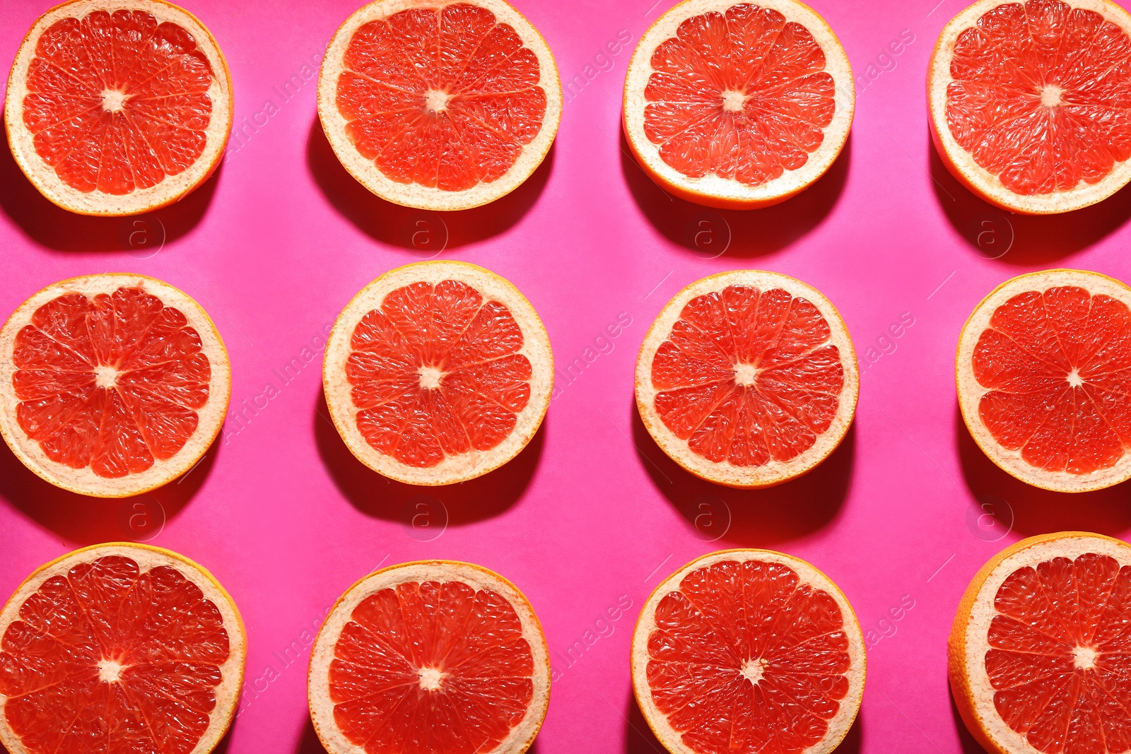 Photo of Flat lay composition with tasty ripe grapefruit slices on magenta background