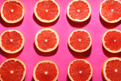 Photo of Flat lay composition with tasty ripe grapefruit slices on magenta background