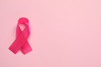 Photo of Pink ribbon on color background, top view and space for text. Breast cancer awareness