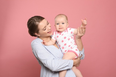 Photo of Portrait of happy mother with her baby on color background