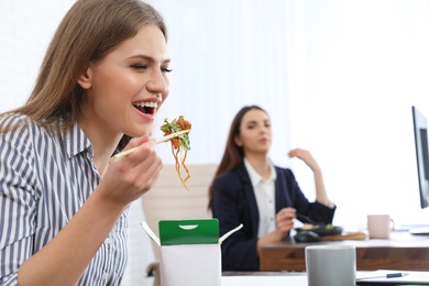 Photo of Office employees having lunch at workplace. Food delivery