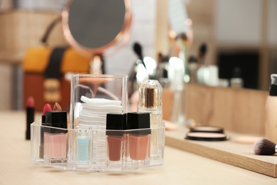 Photo of Organizer with cosmetic products and makeup accessories on dressing table. Space for text