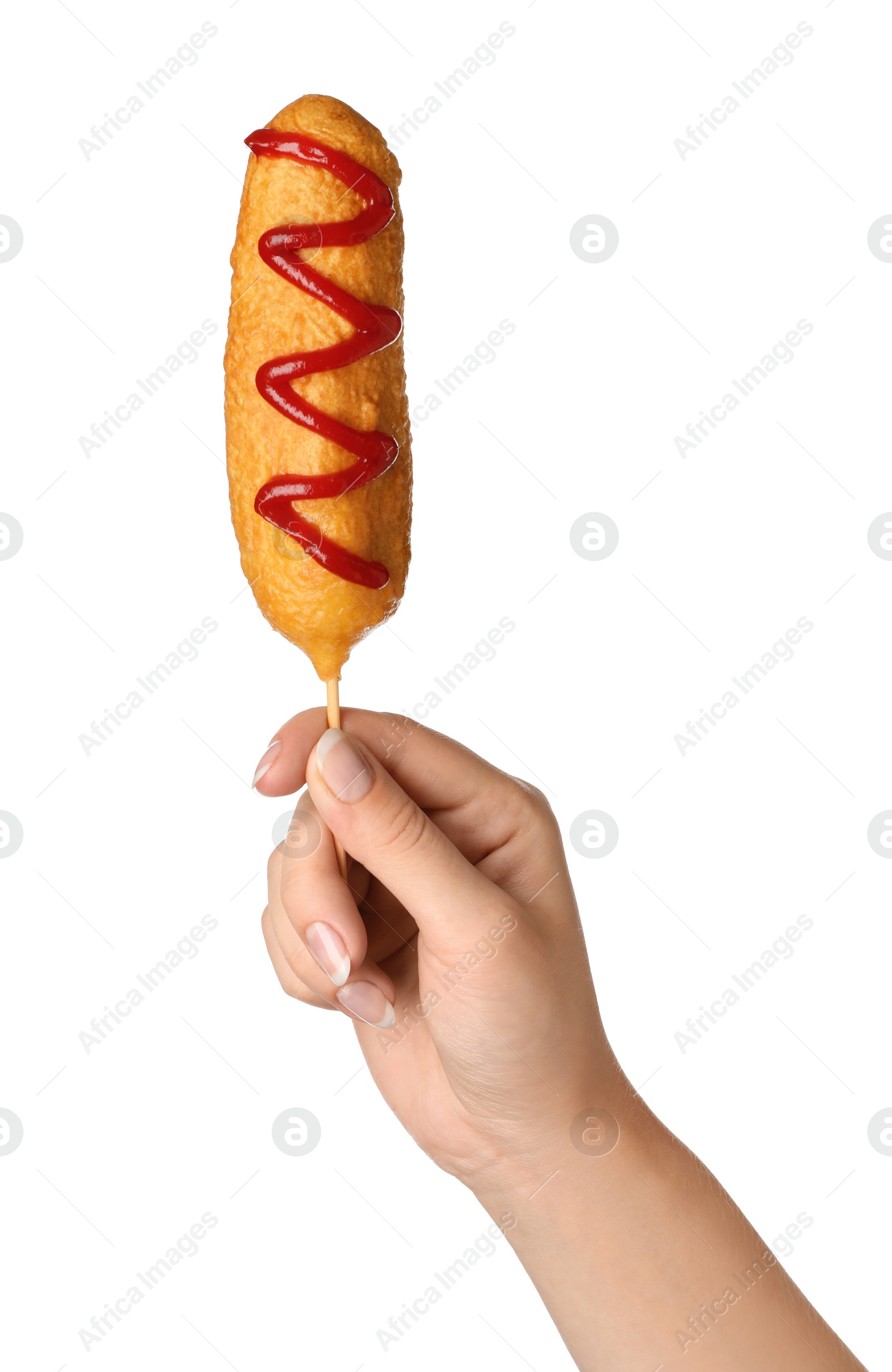 Photo of Woman holding delicious deep fried corn dog with ketchup on white background, closeup