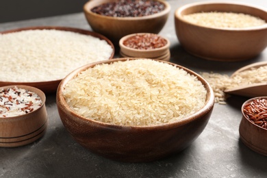 Photo of Brown and other types of rice on grey table