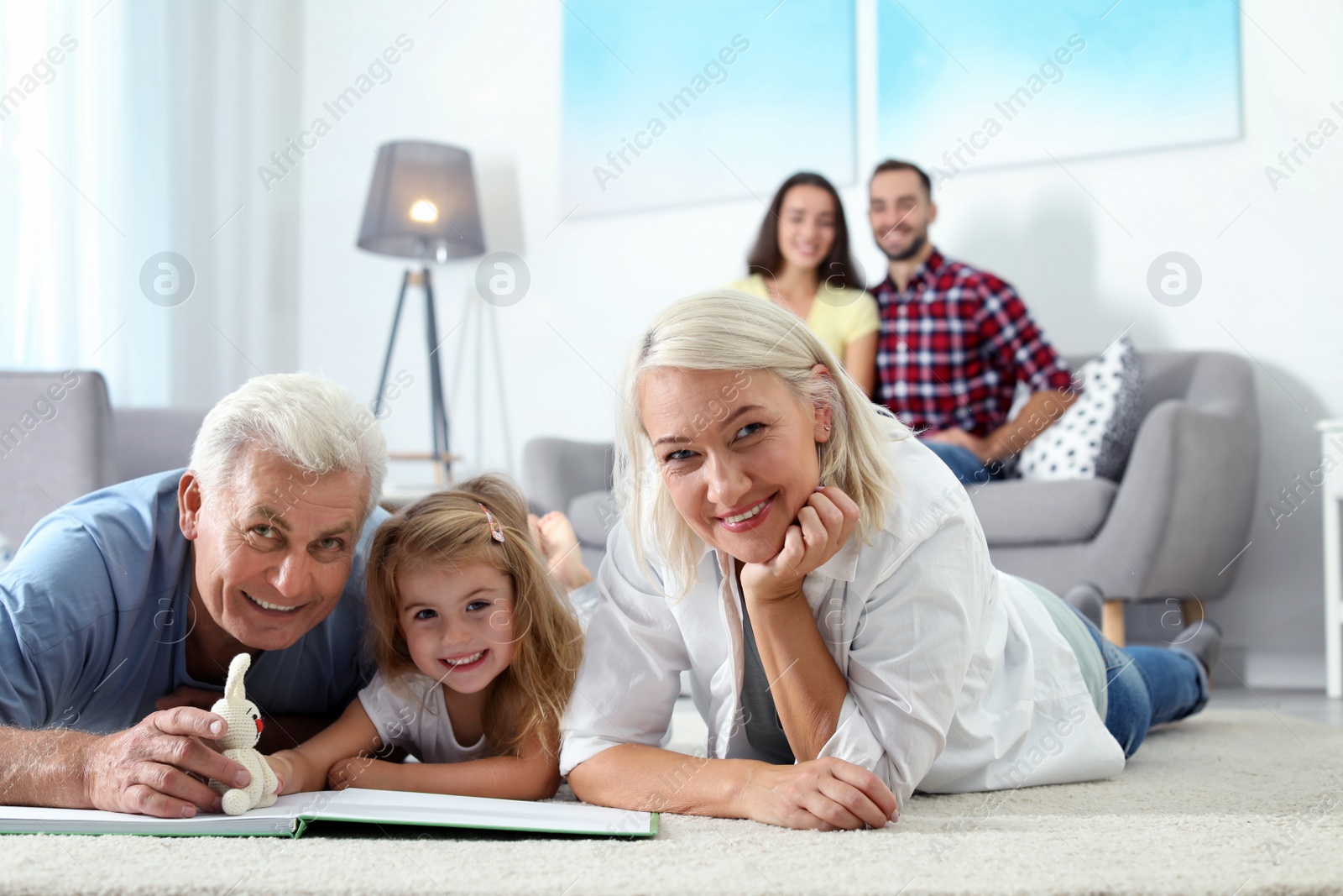 Photo of Mature couple spending time with their granddaughter at home. Happy family