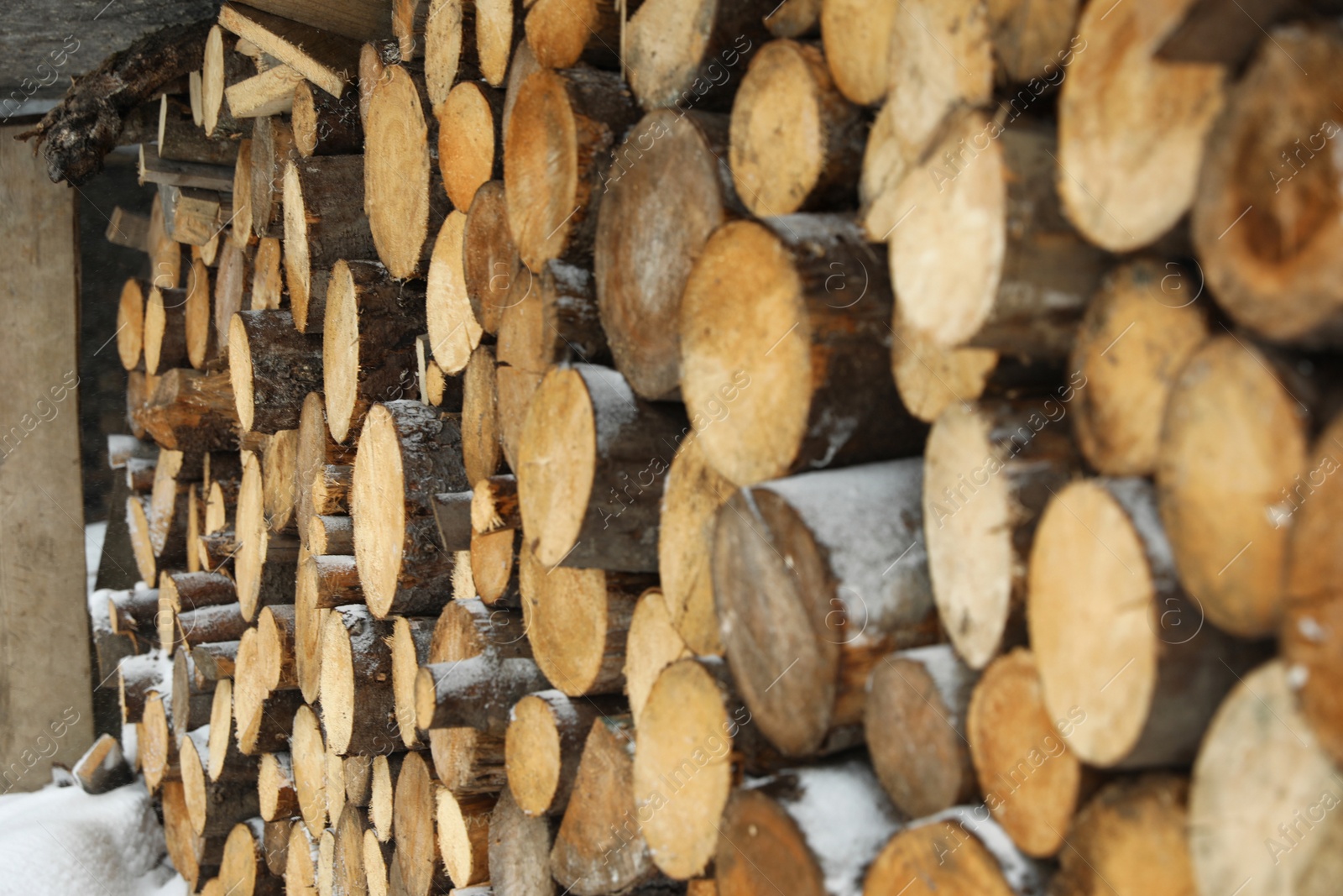 Photo of Stacked firewood outdoors, closeup. Heating house in winter