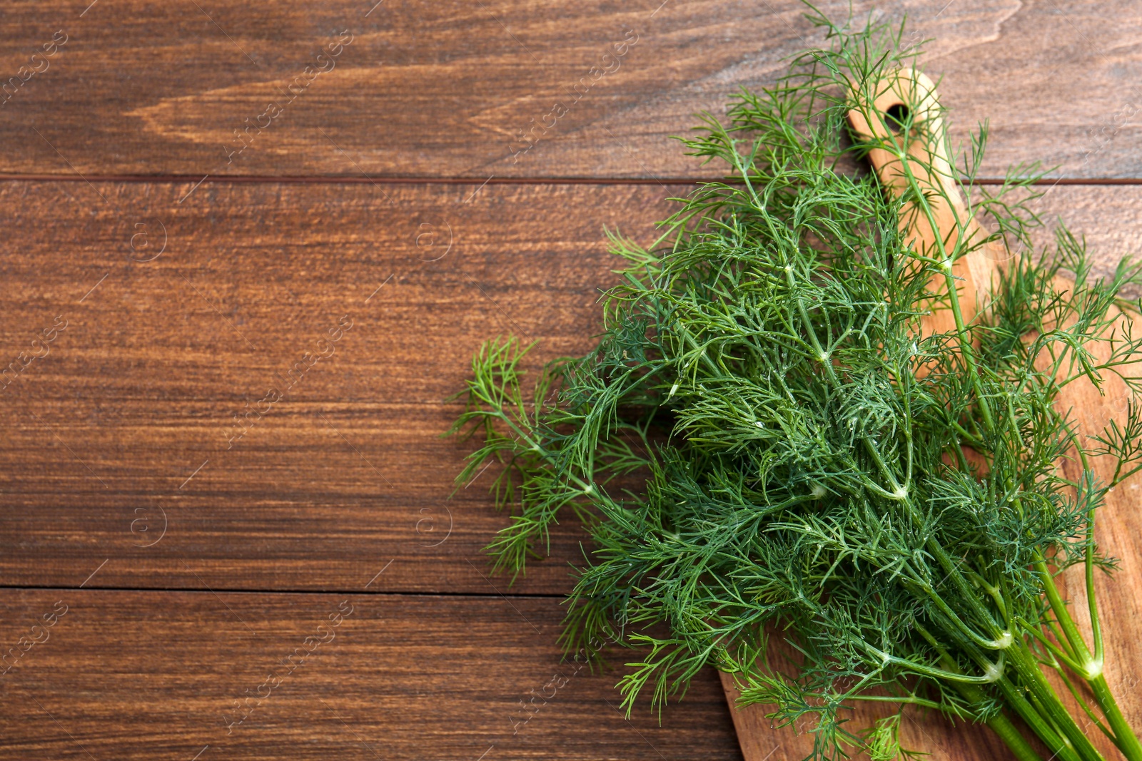 Photo of Fresh green dill on wooden table, top view. Space for text