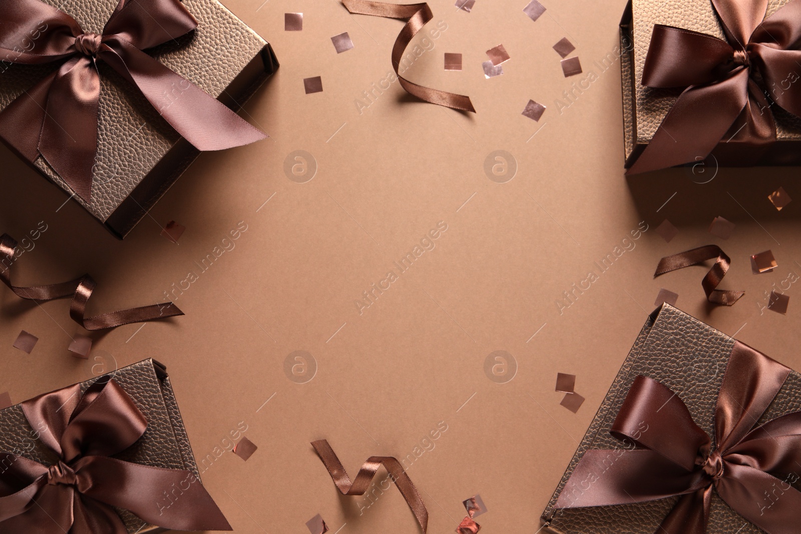 Photo of Frame of beautiful gift boxes and confetti on brown background, flat lay. Space for text