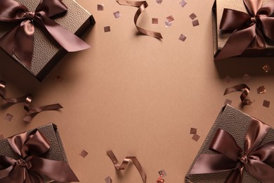 Frame of beautiful gift boxes and confetti on brown background, flat lay. Space for text