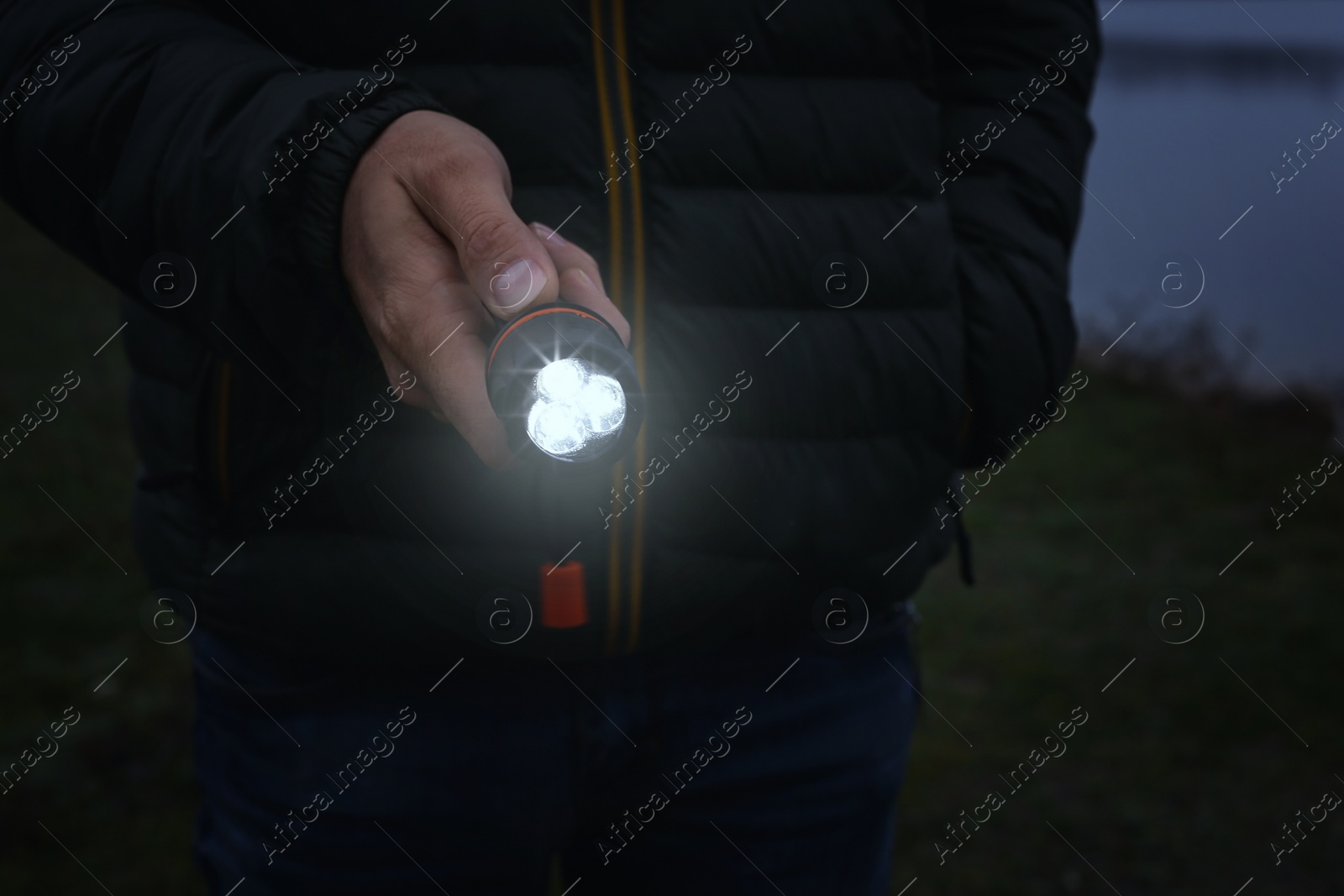 Photo of Man with flashlight walking outdoors, closeup view