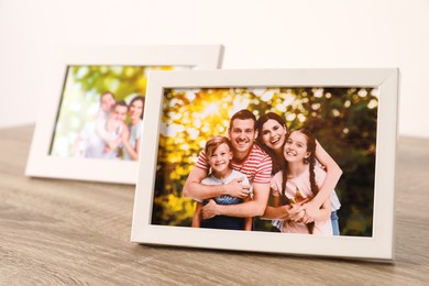 Photo of Frames with family photos on wooden table, closeup