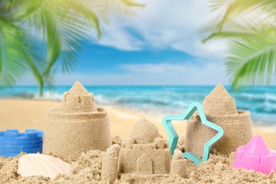 Sand castles with toys on ocean beach. Outdoor play