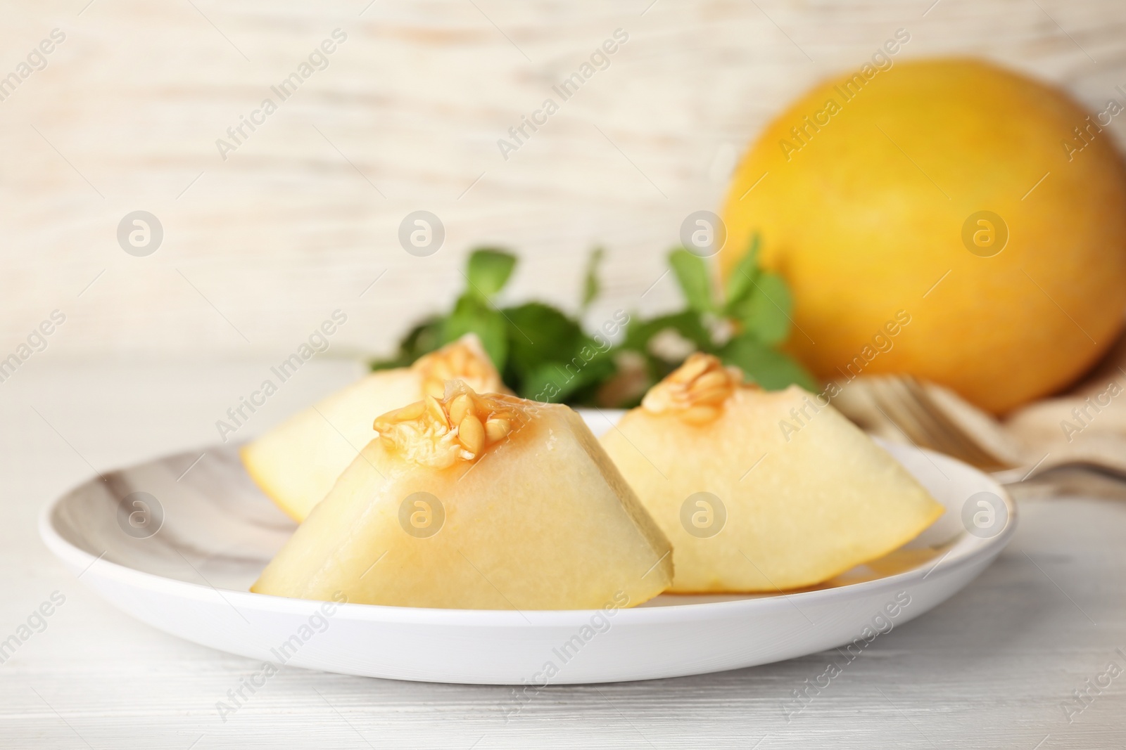 Photo of Plate with cut sweet melon on table