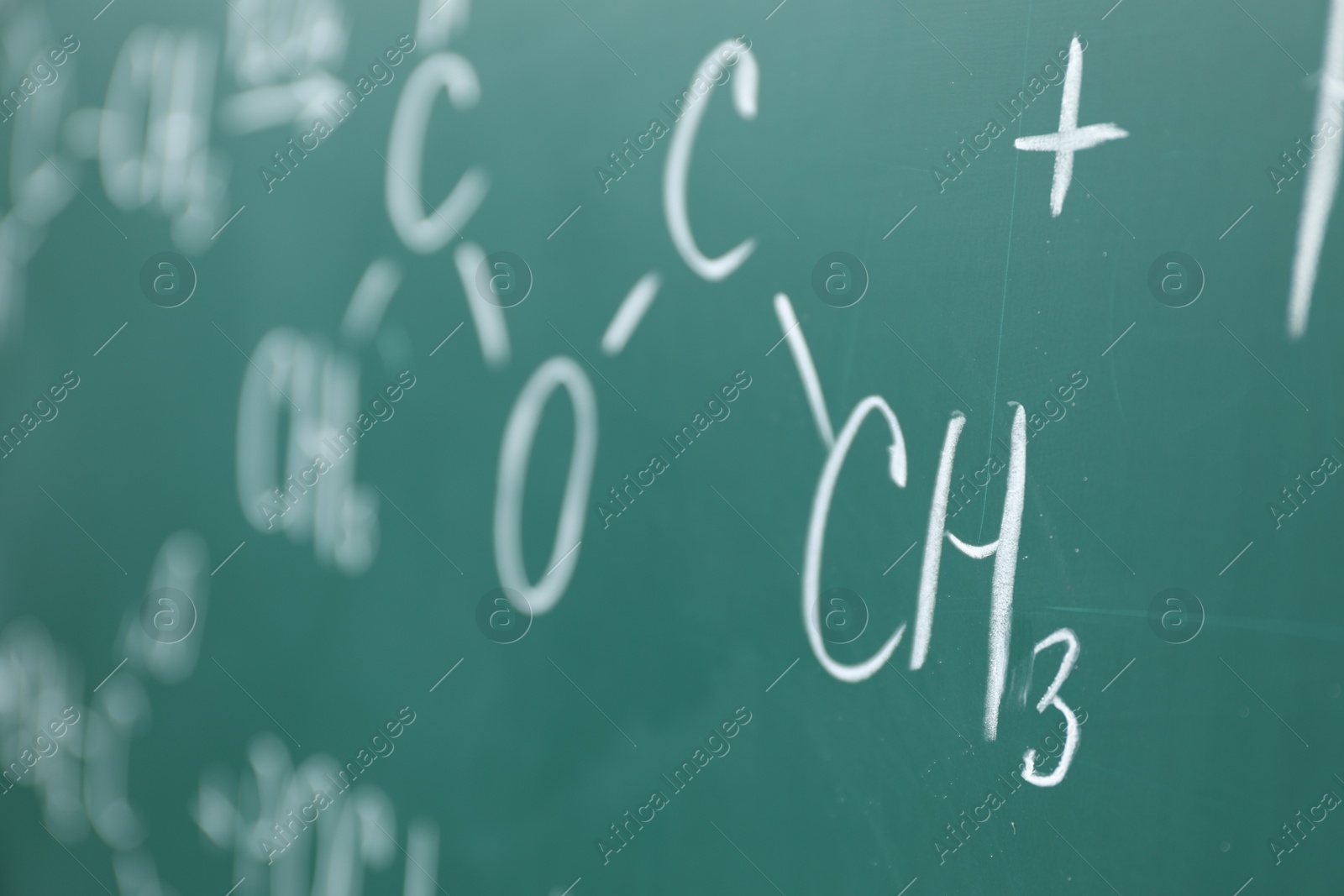 Photo of Chemical formulas written with chalk on green board, closeup