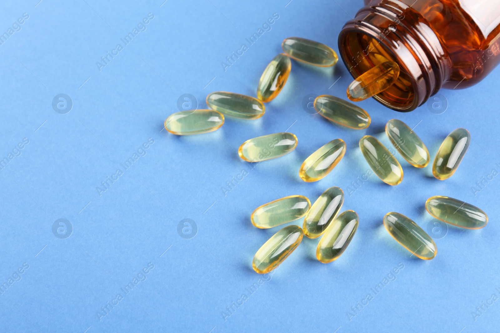 Photo of Jar with vitamin capsules on blue background, above view. Space for text