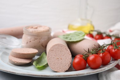 Delicious liver sausages, paste and cherry tomatoes on plate, closeup