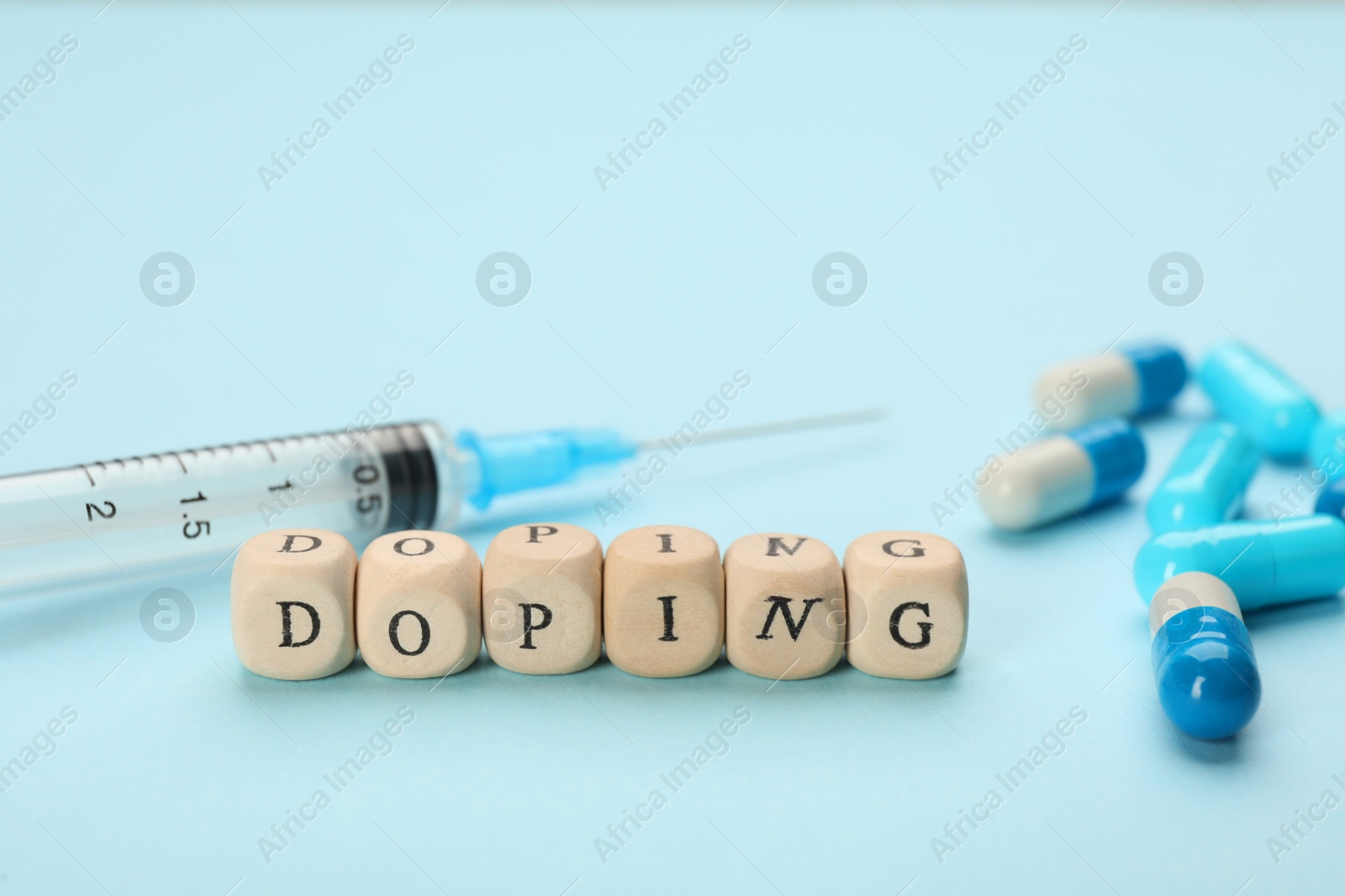 Photo of Wooden cubes with word Doping and drugs on turquoise background