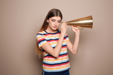 Photo of Young woman with megaphone on color background