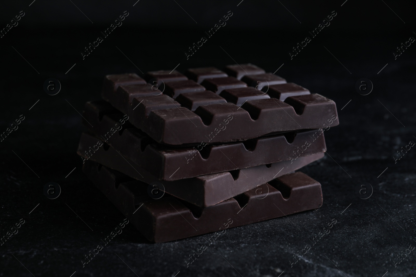 Photo of Tasty dark chocolate bars on black table