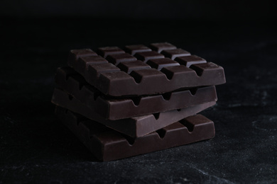 Tasty dark chocolate bars on black table