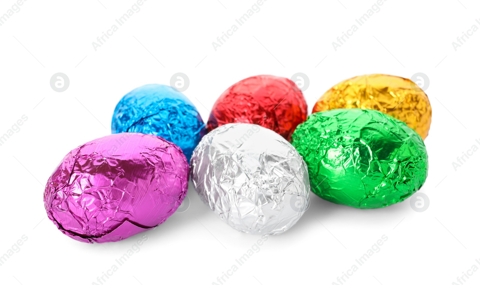 Photo of Many chocolate eggs wrapped in bright foil on white background